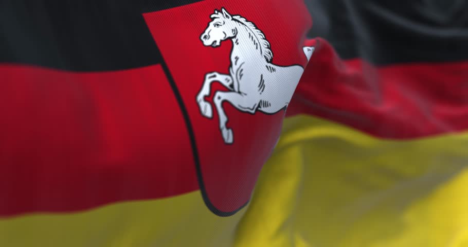 Close-up of Lower Saxony state flag waving. Black, red and yellow stripes with coat of arms in the center. German state. Seamless 3d render animation loop. Slow motion. Selective focus