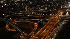 OSAKA, JAPAN - JULY 2023 : Aerial view of high way, road junction and cityscape of downtown. Japanese transportation, street traffic and urban city concept video. Time lapse shot at night.