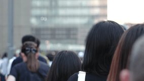 View of crowd of people walking in Osaka, Japan. Back shot of unidentified men and women. Shot in sunset time, busy rush hour. Japanese people and urban city lifestyle concept video.