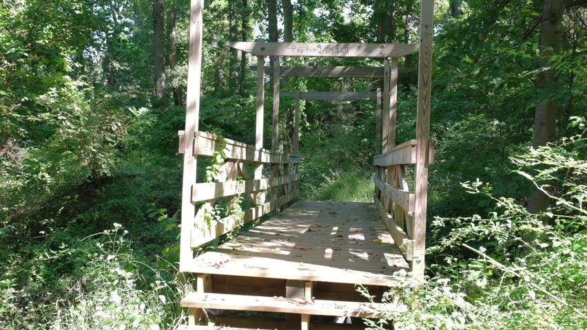 Wooden bridge on the trail in the county park on a sunny day in late summer | Shutterstock HD Video #1109859149
