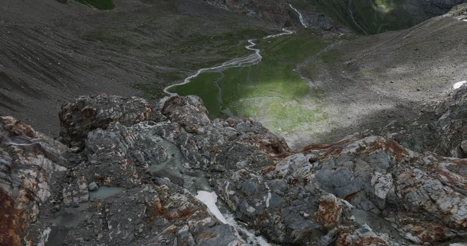 Small mountain lake fed by streams during summer season. Melting glaciers and global warming concept