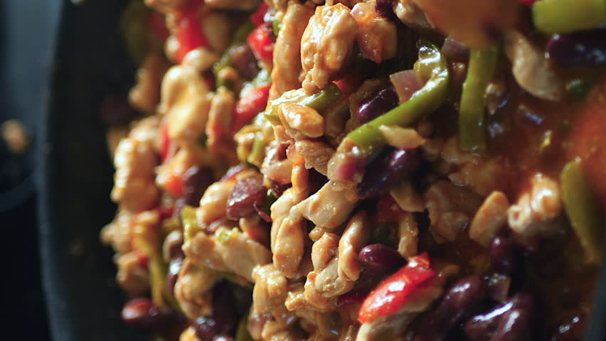 Sprinkling spices on filling for a fajita recipe - vertical orientation