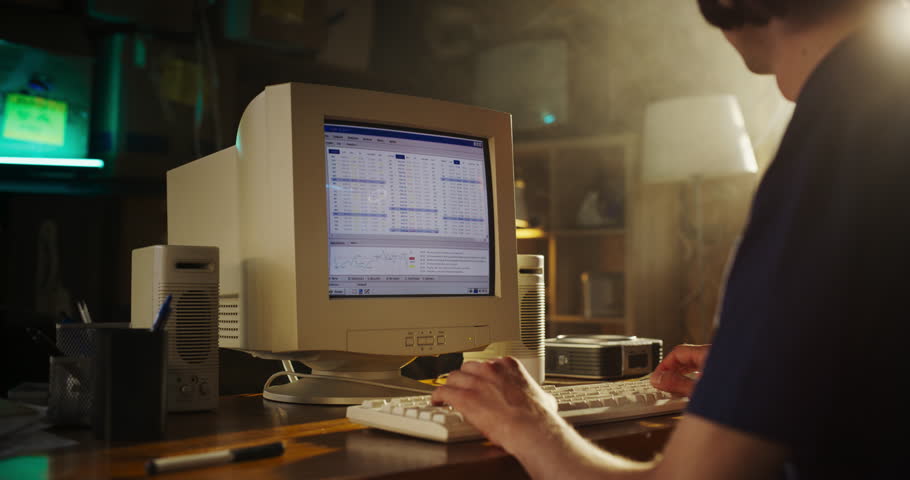 Caucasian Male Stock Trader Using Old Desktop Computer With Financial Candlestick Chart In Retro Garage. Man Analyzing Market Orders Before Entering Trade, Starting Investment Fund In Nineties. Royalty-Free Stock Footage #1109860387