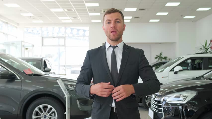 A male dealer talks about a new car at a car dealership. Automotive business Royalty-Free Stock Footage #1109866189