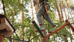 Close up: child foot take step on swinging wooden block in rope park. Little girl walking and balancing, overcome obstacles. Spending time outdoors in adventure park - Powered by Shutterstock - Get 15% off with code: PIKWIZARD15
