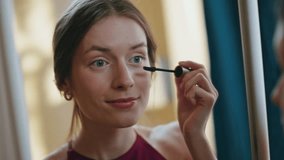 Closeup girl using mascara applying on eyelashes. Woman reflection in mirror doing evening romantic makeup. Attractive relaxed female preparing for date party at home. Beauty routine lifestyle concept - Powered by Shutterstock - Get 15% off with code: PIKWIZARD15