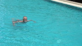 senior couple mixed race ethnicity  husband swimming to wife  . old man and woman exercise  in the pool . mature  people workout . elder sport . Healthy lifestyle. retirement training .  - Powered by Shutterstock - Get 15% off with code: PIKWIZARD15