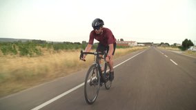 adult male cyclist while cycling on the road and leaving a small town on the horizon - videos of adult people cycling