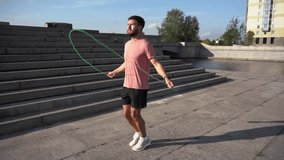 Healthy person warm-up workout active lifestyle. Uses a skipping rope man warm-up cardio workout quickly jumps on the spot intense workout. Slow motion video.