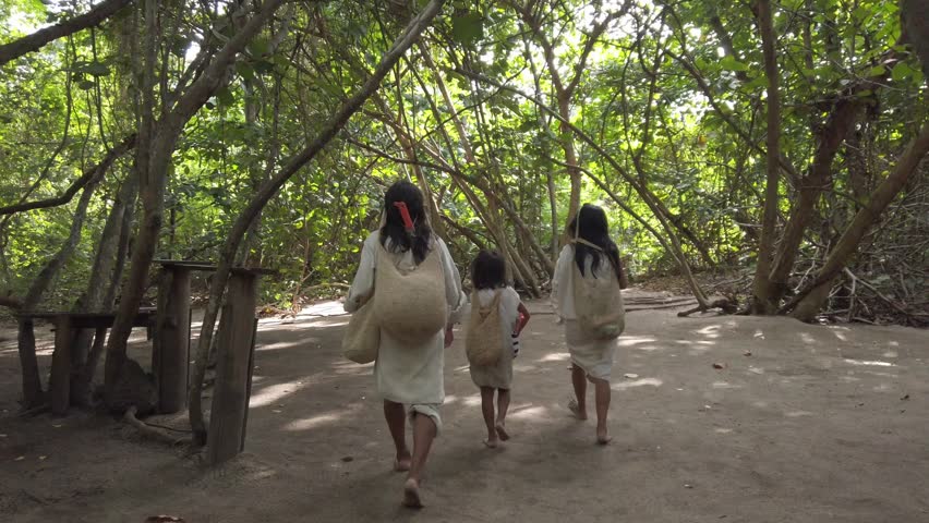 Colombia, Tayrona national park   2022 family mom dad and child of Colombian indigenous tribe people aboriginal live in the forest in Santa Marta - kogi people