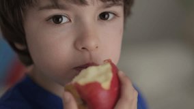 Cute Little Boy Eating Red Apple. Child Eats Fruit. Kid Bites Fruit and Chews Looking at Camera in Kitchen. Healthy Diet Vegetarian. Healthy Nutrition Child Development. Happy Boy Biting Eating Apple. - Powered by Shutterstock - Get 15% off with code: PIKWIZARD15