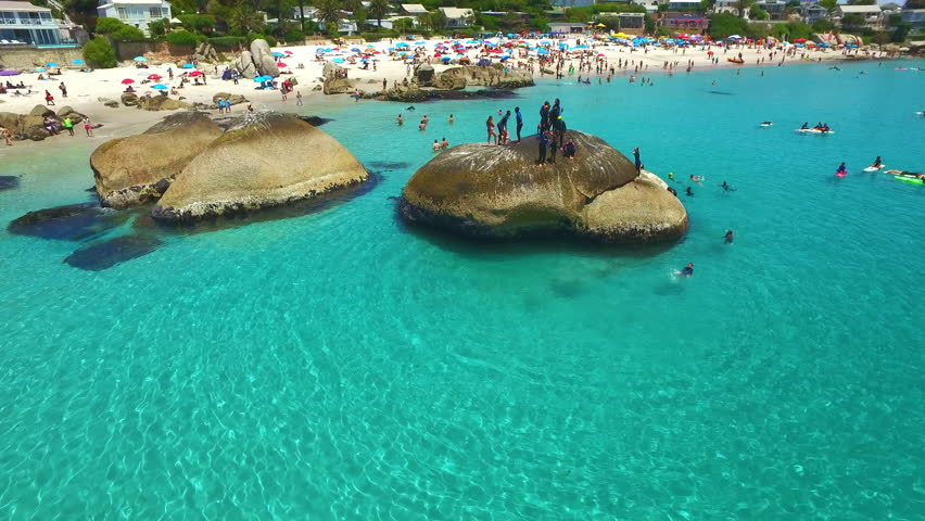 Ocean, beach and drone of crowd on holiday, tropical vacation or summer travel outdoor in Cape Town South Africa. Sea, aerial view and people in water, seascape and tourism to relax or swim in nature