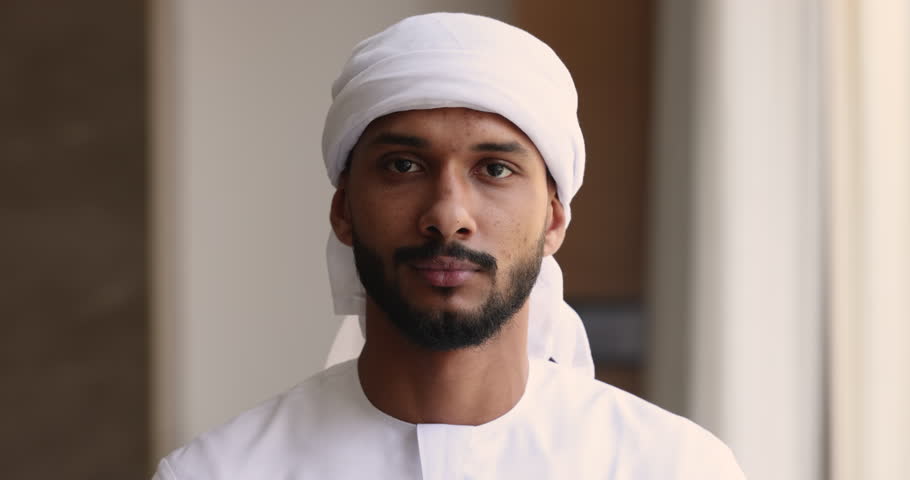 Close up head shot portrait young confident and ambitious Sudanese African business man wear traditional muslim white headscarf and thawb smiling looking at camera posing in office. Career, business Royalty-Free Stock Footage #1109893361
