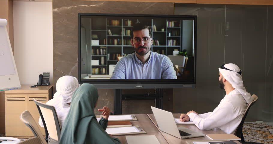 Videoconference of business team in conference room. Diverse company employees having online business conference videocall on tv screen monitor. Remote talk, presentation, virtual group training event Royalty-Free Stock Footage #1109893403