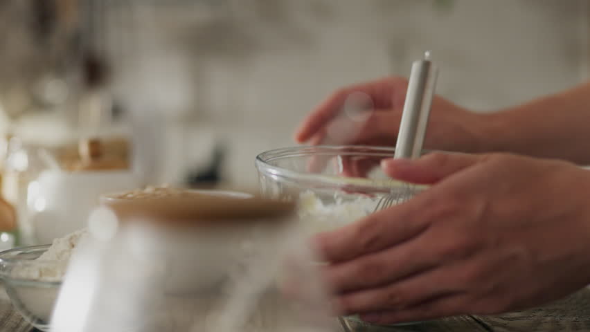 Baking. A white girl in modern clothes adds ingredients to the baking dough. The camera is in motion, a caring mother pours flour to prepare the dough, applies a new mixture of ingredients, bakes