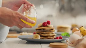 The master chef pours honey on pancakes with berries. Cameras young parent pours yellow honey on pancakes with fruits applies new mixing of different fruits and berries, sweet food - Powered by Shutterstock - Get 15% off with code: PIKWIZARD15