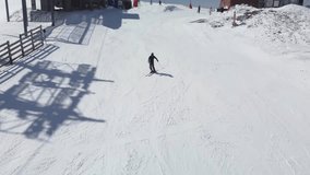 Advanced skier skiing on groomed slope. Professional carving. Aerial video.