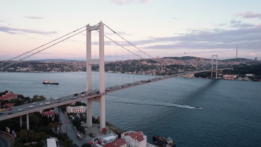 Drone video of Bosphorus in Istanbul during sunset. First and second bridge filmed from above. Turkiye flag waving. Ships passing under the bridge. | Shutterstock HD Video #1109896857