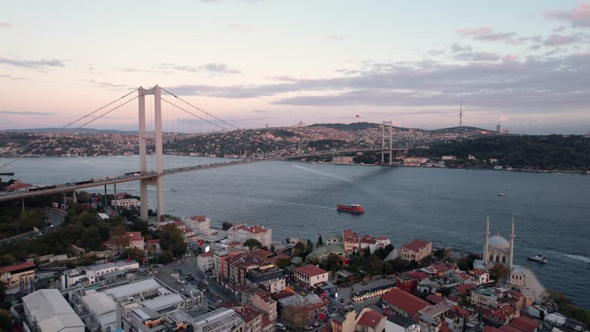 Drone video of Bosphorus in Istanbul during sunset. First and second bridge filmed from above. Turkiye flag waving. Ships passing under the bridge. | Shutterstock HD Video #1109896863