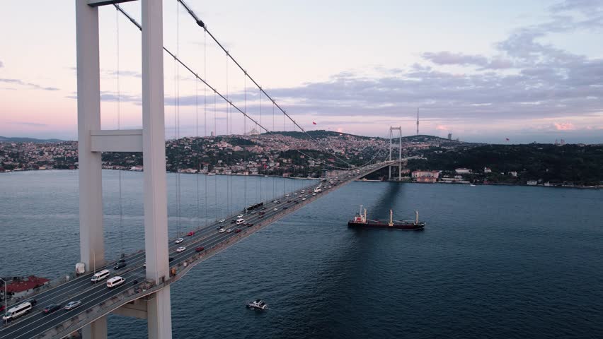 Drone video of Bosphorus in Istanbul during sunset. First and second bridge filmed from above. Turkiye flag waving. Ships passing under the bridge. | Shutterstock HD Video #1109896865