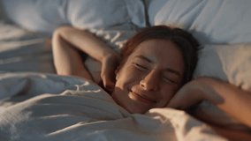 Happy woman stretching bed in sunlight closeup. Carefree smiling girl waking up lying on soft comfortable sheets pillows. Joyful beautiful female enjoy day full of energy. Positive emotions happiness - Powered by Shutterstock - Get 15% off with code: PIKWIZARD15