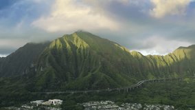 Aerial of Cinematic road with landscape views 4K Hawaii nature. Drone view cars driving by road to tunnel in steep green mountain. Breathtaking Interstate H3 winding highway towards tunnel Oahu island