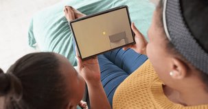 African american mother and daughter using tablet, shopping online on cyber monday, slow motion. Retail business, sale, communication and digital interface digitally generated video.