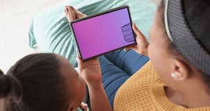 African american mother and daughter using tablet, online shopping on cyber monday, slow motion. Retail business, sale and digital interface digitally generated video.