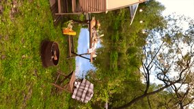 trailer of mobile home or recreational vehicle stands on shore of pond in camping in autumn, table set, family local travel in native country on caravan or camper van and camping life, vertical video