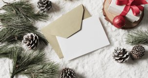 Video of christmas decorations and white card with copy space on snow background. Christmas, decorations, tradition and celebration concept.