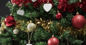 Video of christmas tree with decorations and hearts with copy space. Christmas, decorations, tradition and celebration concept.
