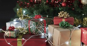 Video of christmas tree with presents and fairy lights with copy space. Christmas, decorations, tradition and celebration concept.
