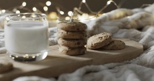 Video of christma cookies, glass of miljk and copy space on white background. Christmas, baking, decorations, tradition and celebration concept.