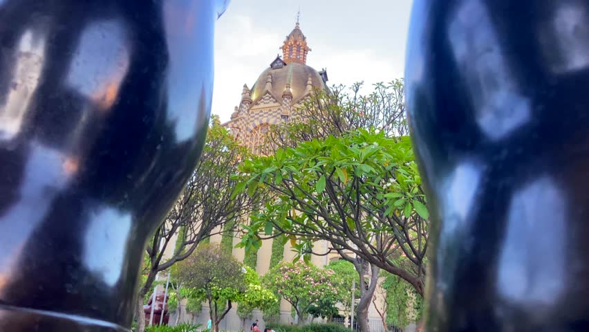 Fernando Botero square main building through legs of his sculpture in Medellin, Colombia