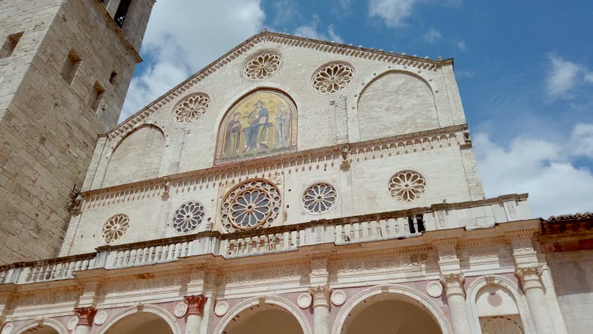Façade of Spoleto Cathedral with mosaic of Jesus Christ, Rose windows and architraved door with sculpted door-posts. Located in Umbria (central Italy).