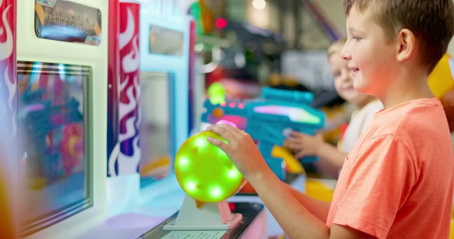Happy kid playing fun games on arcade machine at an amusement park Royalty-Free Stock Footage #1109920957