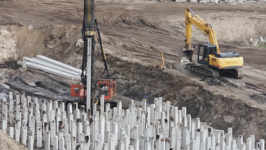 Piling driving machine at a construction site drives a pile into the ground before building the foundation. Top view. Royalty-Free Stock Footage #1109922185
