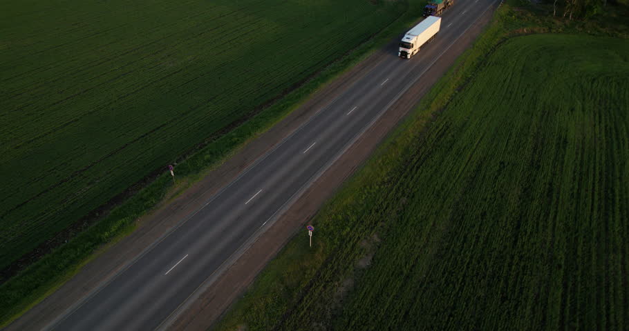  White truck with a Semi Truck is driving along the highway, aerial shot. Drone view. Cargo transport. Logistics Industry. Freeway trucks traffic Royalty-Free Stock Footage #1109925881