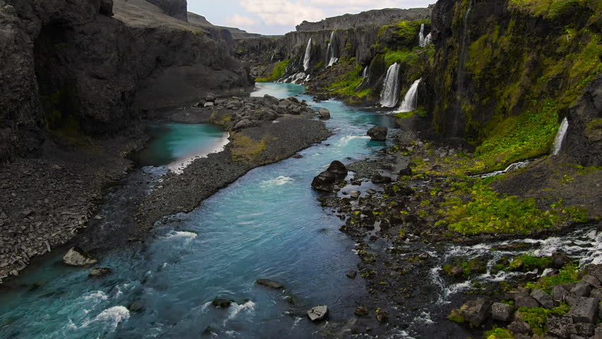 fantasy like canyon valley of tears with several waterfalls falling in the blue river with lush vegetation in the desertic lava landscape Sigoldugljufur iceland Royalty-Free Stock Footage #1109927555