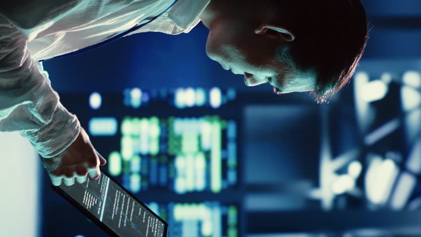 Vertical video Trained asian admin running code and programming on tablet, troubleshooting and upgrading high tech facility equipment designed to accommodate servers, networking systems and storage
