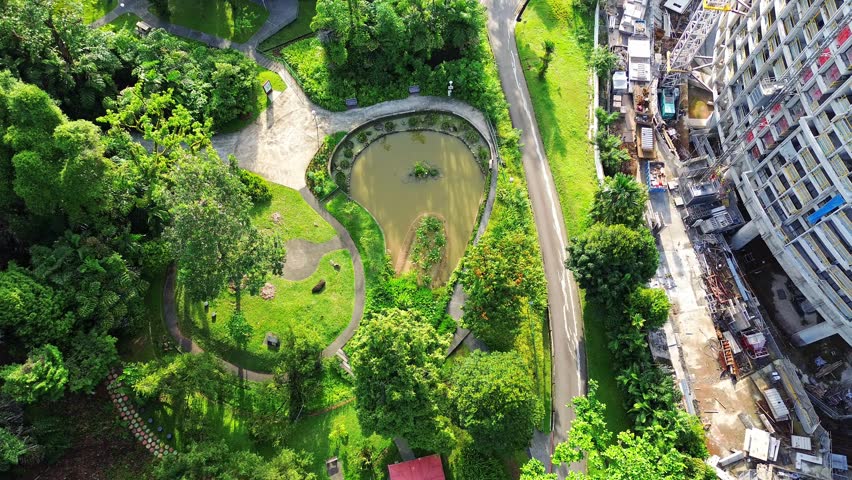 Aerial 4k footage of Singapore city skyline. A reveal shot of skyscrapers, residential buildings and cars during bright sunny day.