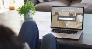Caucasian woman at table using laptop, online shopping for beauty products, slow motion. Retail business, sale and digital interface digitally generated video.