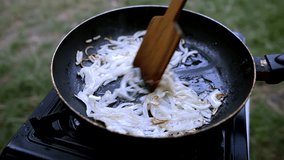 Fried Onion In Pan. Vegetable Cooked In Hot Oil. Video Recipe. Cooking Vegan Food In Frying Pan. Chopped Onions Fry In  Pan Summer Picnic. Onion Frying In Olive Oil. Roasted Caramelized Onions Cuisine