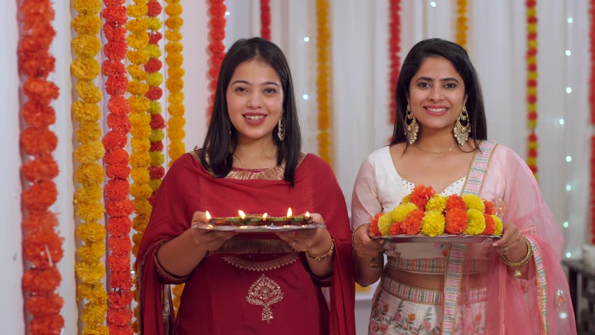 Two petty females in traditional clothes greeting guests on Diwali - posing for the camera, Diwali festival, Indian, Indian culture. Beautiful young woman with her sister celebrating Diwali festiva... Royalty-Free Stock Footage #1109940211