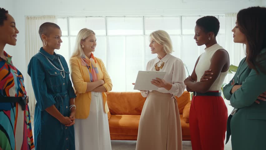 Cinematic footage of a multiethnic group of women managing new projects in a start up business. Female colleagues working as a team in the office wearing elegant colored diverse outfits Royalty-Free Stock Footage #1109940365