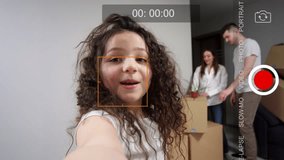 A little girl blogger runs her own broadcast. Shows off about his family and new apartment via smartphone. Concept of buying an apartment and moving