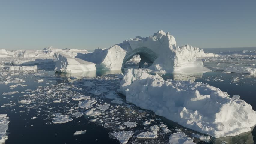 Gaint iceberg with ice cave melting in the ocean. Icebergs from melting glacier float in Disco Bay, near Ilulissat, Greenland. Aerial shot, climate change concept Royalty-Free Stock Footage #1109941127