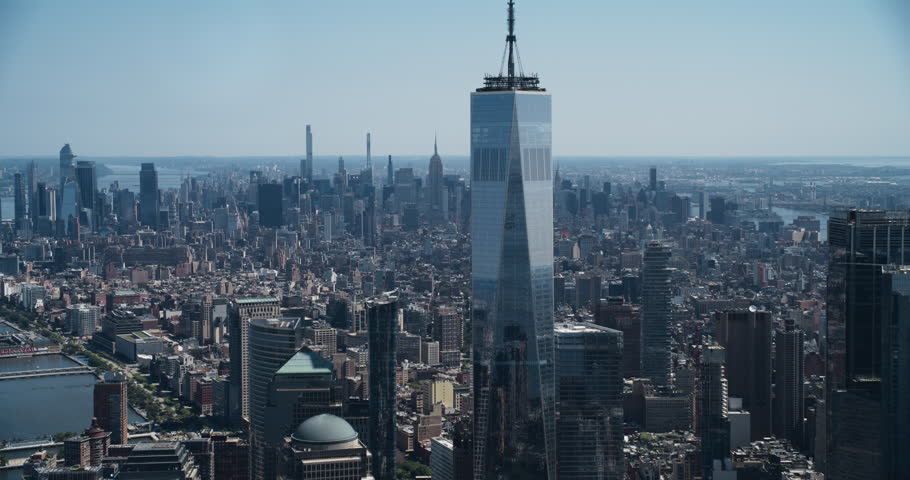 Aerial Footage of a Camera Locked on Top of the One World Trade Center Skyscraper with Antenna. Helicopter Flying Around the Glass Building with a View on Greater New York City Boroughs