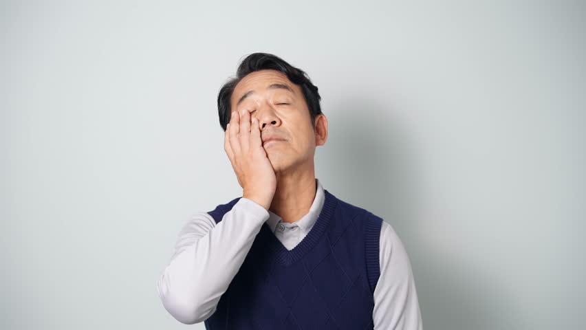Depressed middle-aged Asian man wearing casual wear in white background. Royalty-Free Stock Footage #1109951415