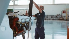 Aircraft engineer inspecting propeller on an airplane in an airplane hangar, aircraft maintenance and servicing. - Powered by Shutterstock - Get 15% off with code: PIKWIZARD15